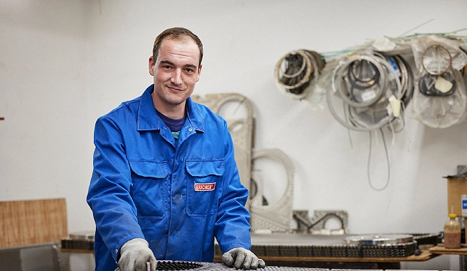 Ein BUCHEN Mitarbeiter reinigt eine Platte und guckt dabei zufrieden in die Kamera.