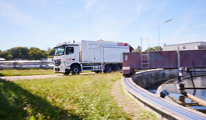 Ein weißer Saugbagger fährt durch eine Kläranlage