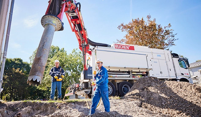 Zwei Mitarbeiter bedienen einen Saugbagger auf einer Baustelle