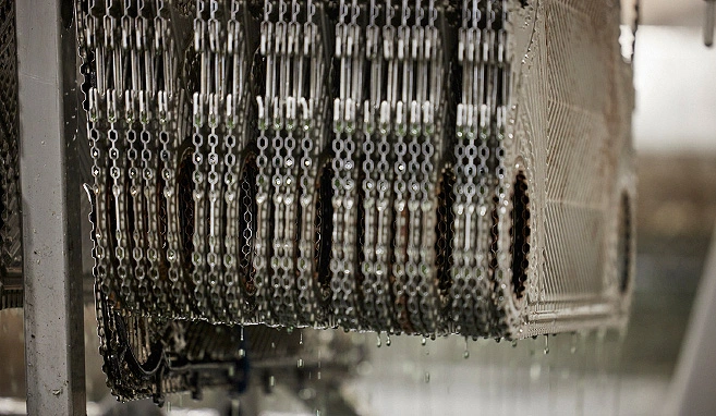 Viele Platten des Plattenwärmetauschers sind hintereinander aufgereiht und werden in einem Chemiebad gereinigt.